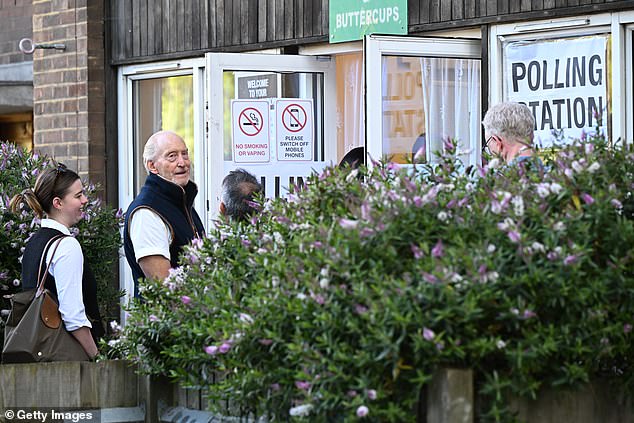 He wore a navy gilet and white T-shirt as he queued up to cast his vote early on Thursday morning