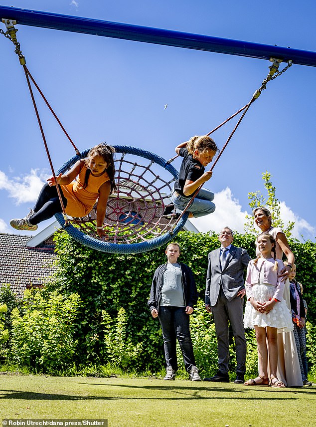 Smiling as the girls playing on the swing gathered pace, the royal looked typically radiant