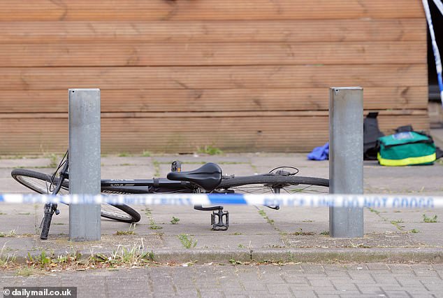 A discarded bicycle can be seen behind a police cordon in Allcot Close