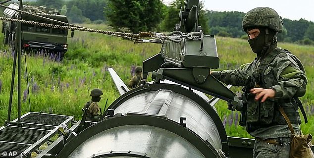 Russian soldiers load a Iskander-M short-range ballistic missile launchers at a firing position as part of Russian military drill intended to train the troops in using tactical nuclear weapons on June 12