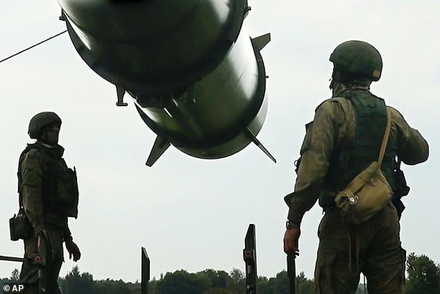 Russian soldiers load a Iskander-M short-range ballistic missile launchers at a firing position as part of Russian military drill intended to train the troops in using tactical nuclear weapons in June