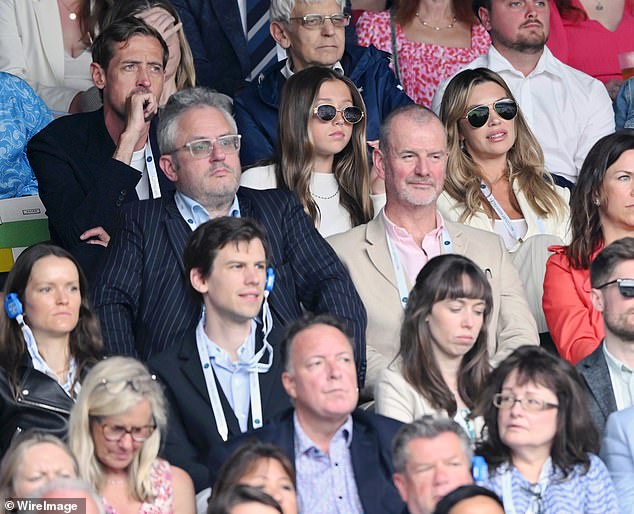 The professional footballer cut a smart casual figure in a navy blazer and white T-shirt as he watched the action unfold