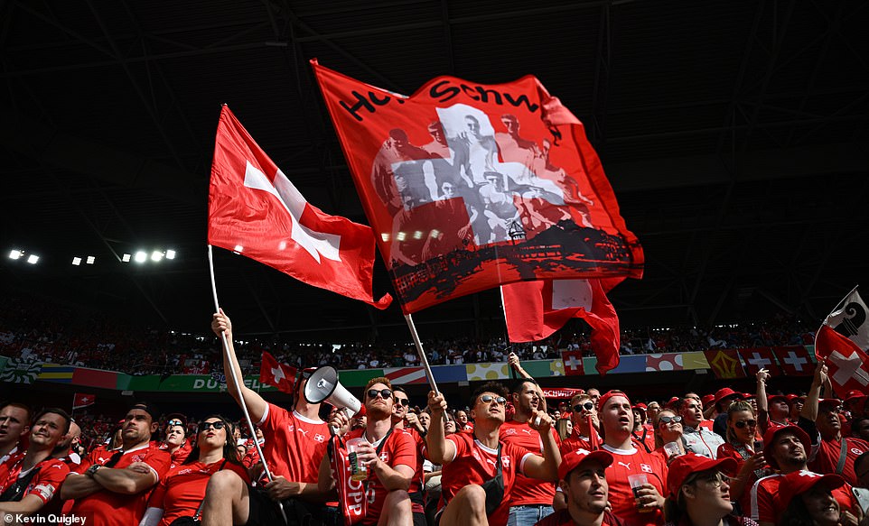 Switzerland supporters made their support heard and seen in Dusseldorf as artistic flags were erected and a fan carrying a megaphone tries to raise the noise levels