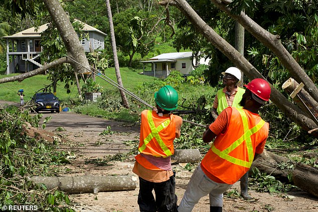 An emergency crew clears the main road after Hurricane Beryl passed the day before, in the northern Saint Patrick parish town of Sauteurs, Grenada on July 2, 2024