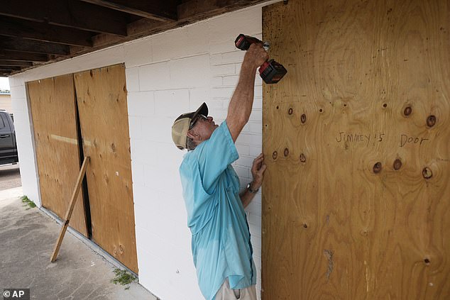 Jimmy May boards windows as he prepares for Hurricane Beryl's arrival, Sunday, July 7, 2024, in Port Lavaca, Texas