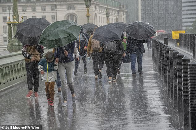 People run for cover from the heavy rain in Westminster yesterday