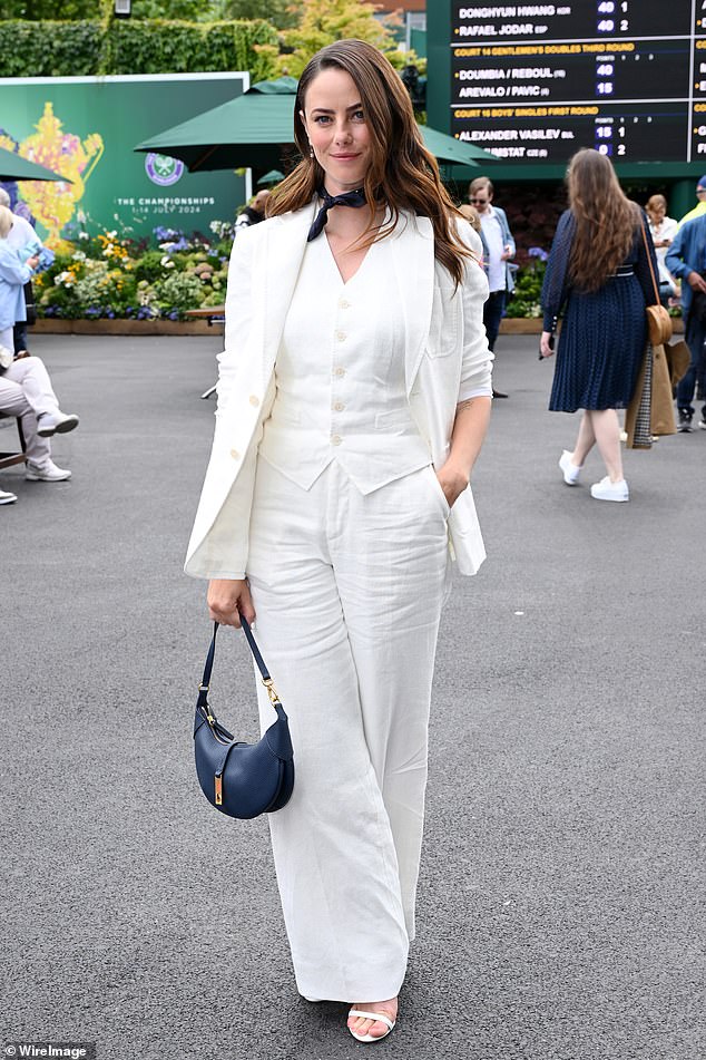 She boosted her height with strappy white heels and accessorised with a navy neckerchief and sleek leather bag