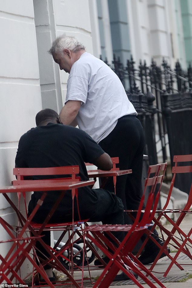 Eamonn cut a casual figure in a grey T-shirt and black trousers as he struggled making his way into a London café on Friday