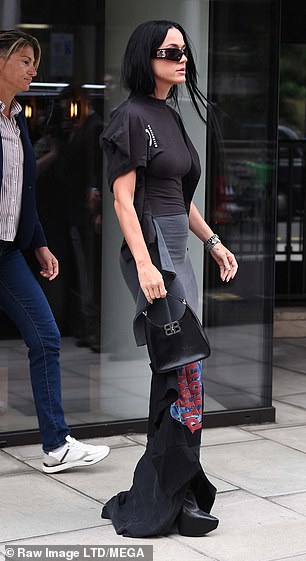 Katy boosted her height with black leather boots and wore dark shades to cover her eyes