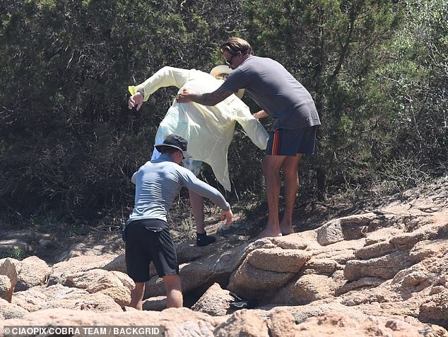 Rod was seen being helped over the rocks on the beach as he went for a stroll