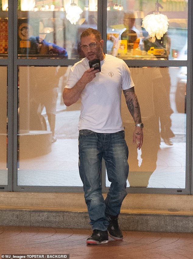 The actor, 46, put on a casual and trendy display in a tight-fitted white T-shirt, showing off his toned biceps and array of tattoos as he briefly left the restaurant to take a phone call