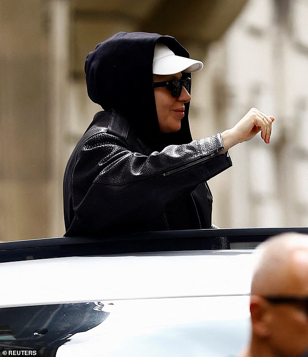 The hitmaker surprised fans as she jumped through the roof and waved as she drove around the French capital