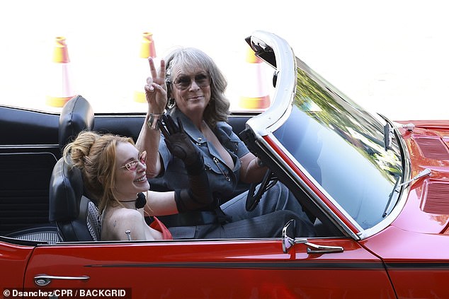 Then Lindsay was spotted in a red convertible car as Jamie Lee flashed a peace sign