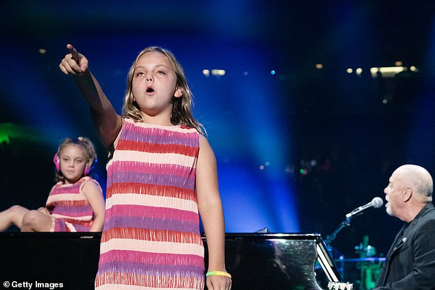 For his history-making 150th show at the World's Most Famous Arena, Della Joel took center stage for her performance with her father on piano and her sister sitting back in decked out in an identical minidress