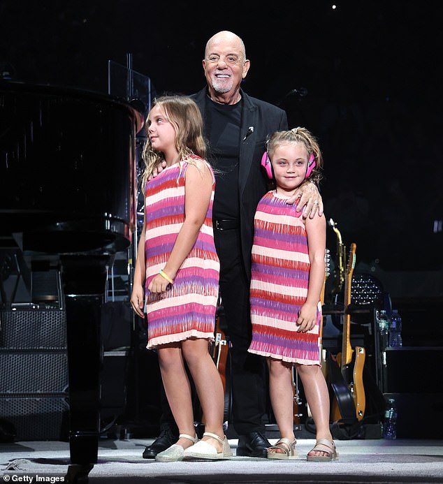 The musician was all smiles as he snuggled up with his two daughters