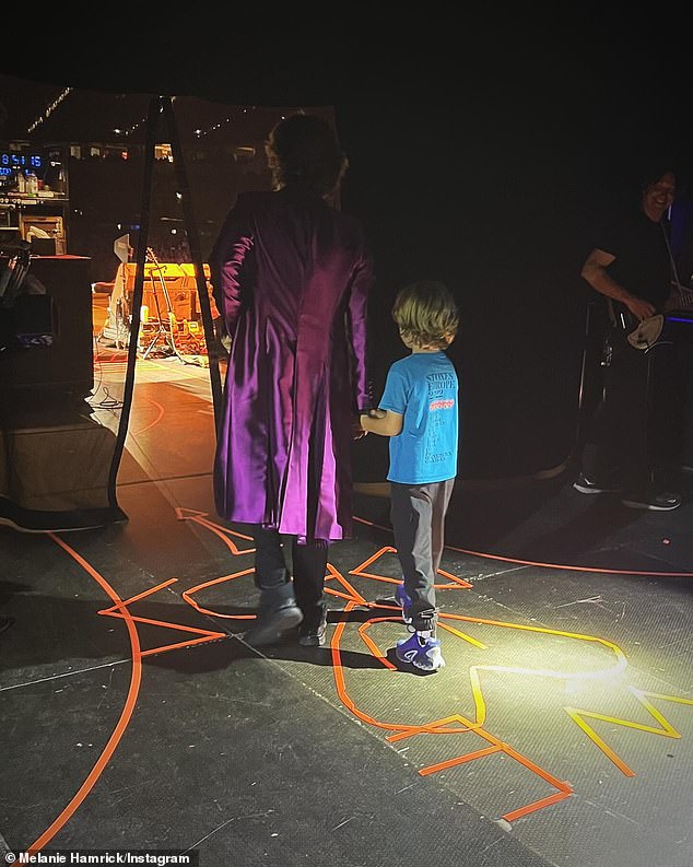 It was followed by a heart-melting snap of Mick holding his son's hand behind the scenes ahead of a stage entrance