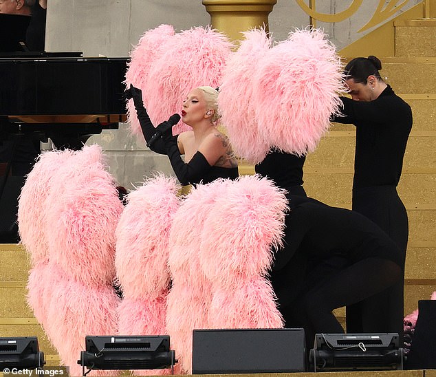 Dancers used pink feathers to surround the singer