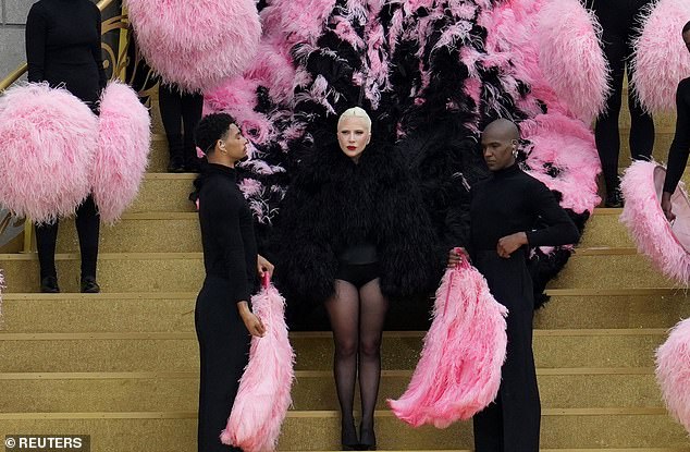 Gaga first made her way down the steps in a flowing feathered coat