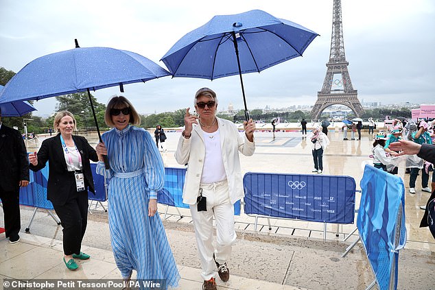 Anna and Baz shielded themselves from the rain with blue umbrellas