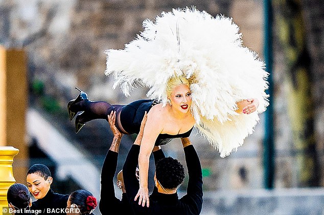 The songstress was lifted above dancer's heads during the set that took place on a sweeping golden staircase ahead of her rumoured duet with Celine Dion, 56