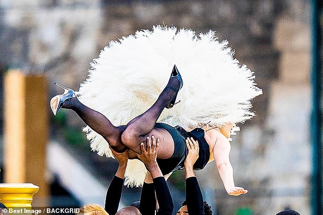 Gaga beamed as she was lifted high by two dancers