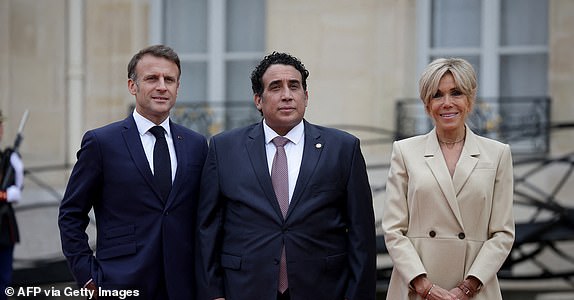 France's President Emmanuel Macron (L) and his wife Brigitte Macron (R) greet Libya's Presidential Council Chairman Mohamed Younis al-Menfi (C) on arrival ahead of a reception for heads of state and governments ahead of the opening ceremony of the Paris 2024 Olympic Games, at the Elysee presidential palace in Paris, on July 26, 2024. (Photo by Valentine CHAPUIS / AFP) (Photo by VALENTINE CHAPUIS/AFP via Getty Images)