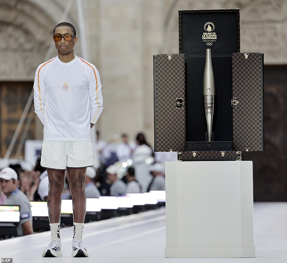 Rapper and designer Pharell Williams posed next to a trunk containing the Olympic torch as part of the 2024 Summer Olympics Torch Relay