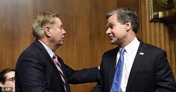 FBI Director Christopher Wray, right, talks with Senate Judiciary Committee Chairman Sen. Lindsey Graham, R-S.C., right, before he sits down to testify before the committee on Capitol Hill in Washington, Tuesday, July 23, 2019. Wray's appearance before a Senate committee could be something of a preview of the intense questioning special counsel Robert Mueller is likely to face in Congress the next day. (AP Photo/Susan Walsh)