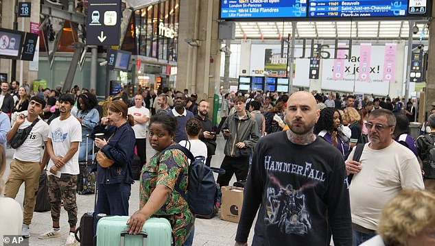 Hours before the grand opening ceremony, travelers are stranded at the Gare du Nord train station in Paris