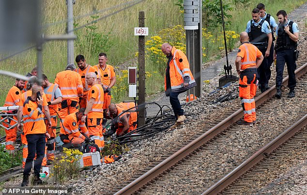 SNCF employees and French gendarmes inspect the scene of a suspected attack on the high speed railway network at Croiselles, northern France on July 26, 2024