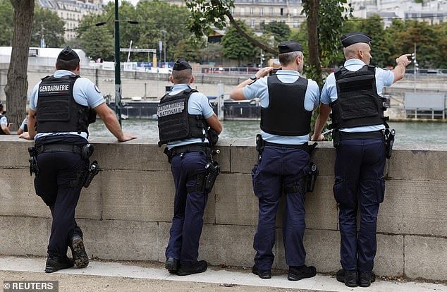 French gendarmes stand in position nearby the river Seine as the security perimeter for the opening ceremony is deployed