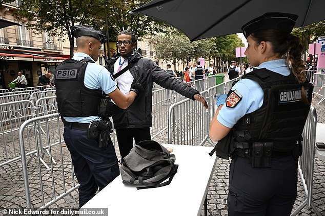 Armed police guards search bags at the entrance to the Opening Ceremony