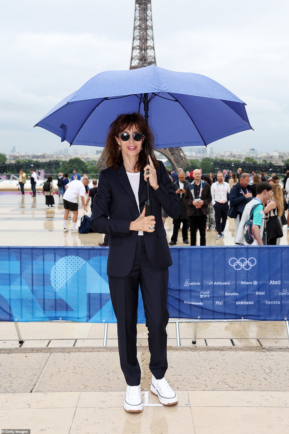 French actress  Anne Parillaud was one of many stars to arrive with a  navy blue umbrella amid the threat of heavy rain