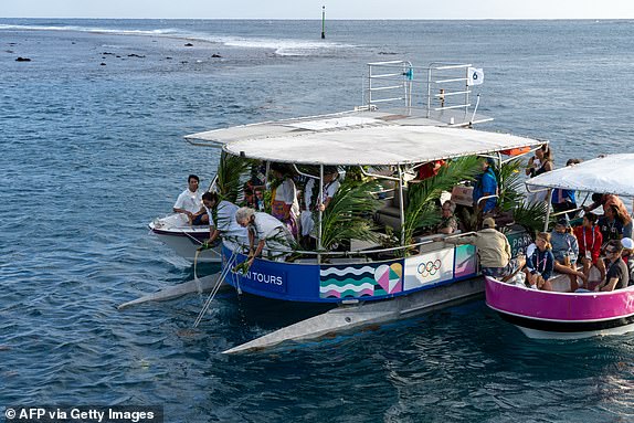 Ceremony master Tunui Salmon (C) performs the Water ceremony on a boat in the Hava'e pass in front of the Teahupo'o surf spot on the island of Tahiti, French Polynesia on July 20, 2024, ahead of the opening ceremony of the Paris 2024 Olympic and Paralympic Games. (Photo by Jerome Brouillet / AFP) (Photo by JEROME BROUILLET/AFP via Getty Images)