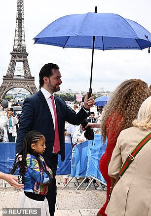 Alex Ohanian holding Serena Williams' umbrella