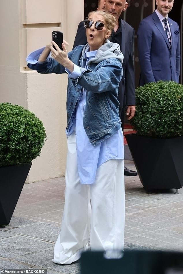 Celine Dion looked in awe as fans swarmed outside her hotel in Paris on Friday amid rumours she will perform at the 2024 Olympic Games