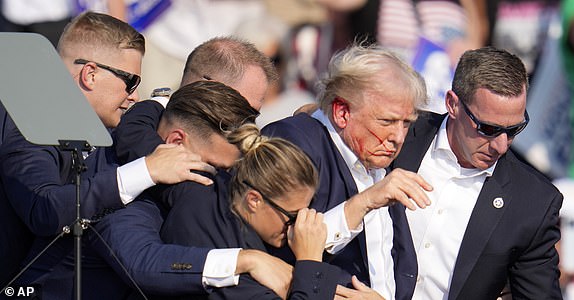 Republican presidential candidate former President Donald Trump is helped off the stage by U.S. Secret Service agents at a campaign event in Butler, Pa., on Saturday, July 13, 2024. (AP Photo/Gene J. Puskar)