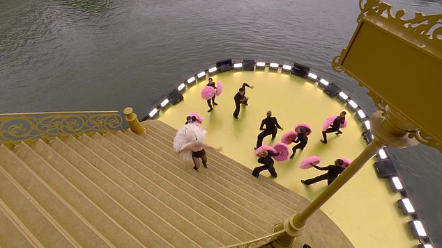 Her elaborate stage painted in hues of yellow was built directly on top of the dark, murky water of the River Seine