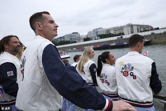 Tennis player Andy Murray, of Great Britain, looks on while riding in a boat along the Seine River  during the opening ceremony for the 2024 Summer Olympics in Paris, France, Friday, July 26, 2024. (Naomi Baker/Pool Photo via AP)