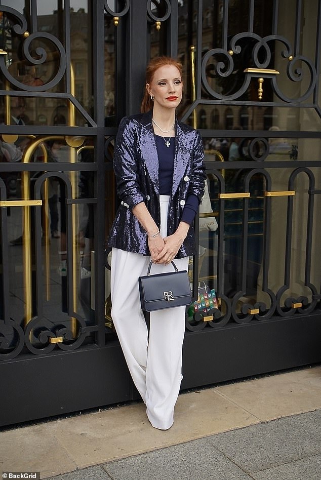 She had her red hair pulled back and up into a sleek ponytail and wore layered silver and pearl necklaces