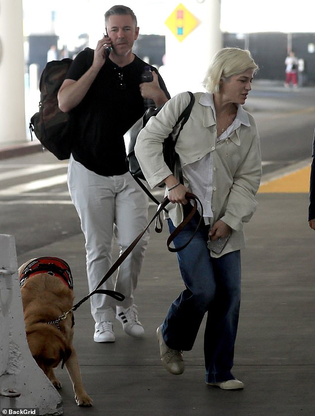 She dressed down in a white blouse and a cream-colored sweater that was partially buttoned at the front as well as denim jeans