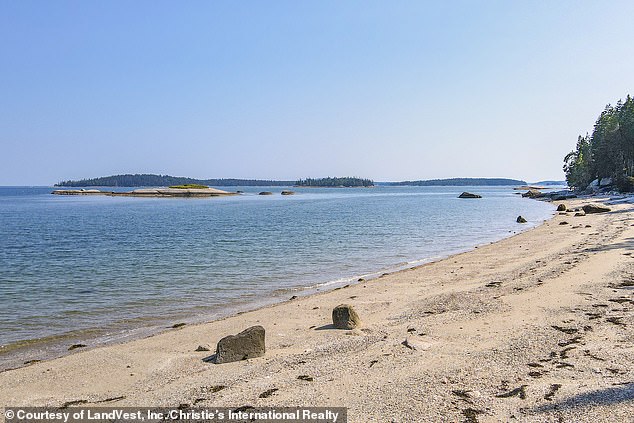 A stone pathway leads people to the wondrous private beach (pictured) near the home that is great for bonfires, boating, kayaking and sea glass hunting