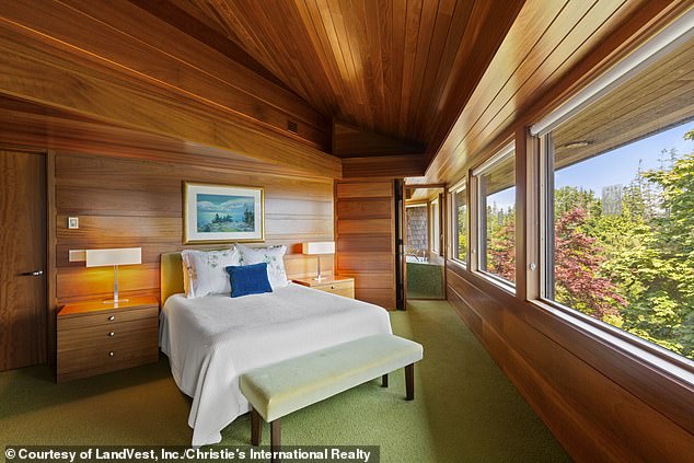 One of bedrooms (pictured) is located down a flight of stairs and is covered from head to toe in sleek wood and green carpeting