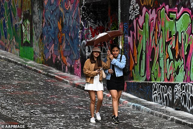 Victoria has a chance of showers and will experience damaging gusts - especially on Wednesday when the winds could reach 100km off the coast (pictured people walking in Melbourne)