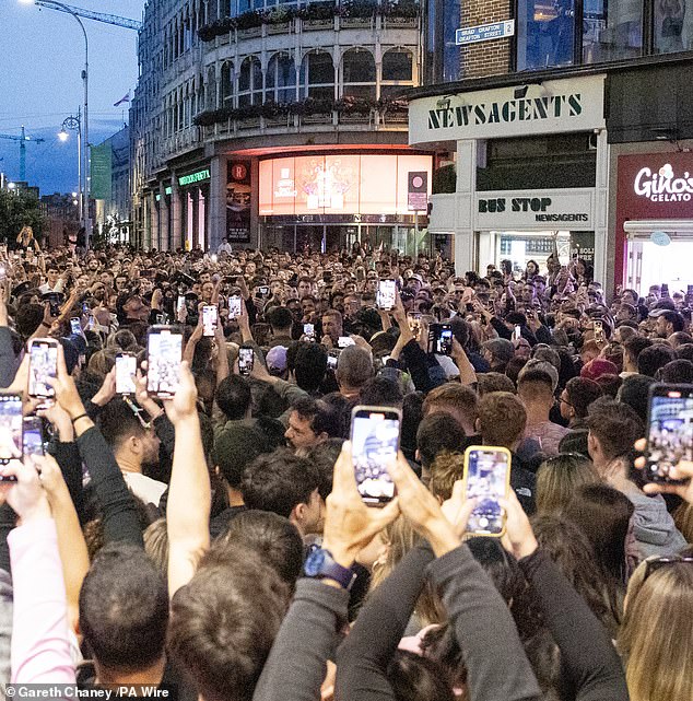 They were met with cheers and applause as the upstairs windows of various shops were opened to reveal several professional cameras filming the action below