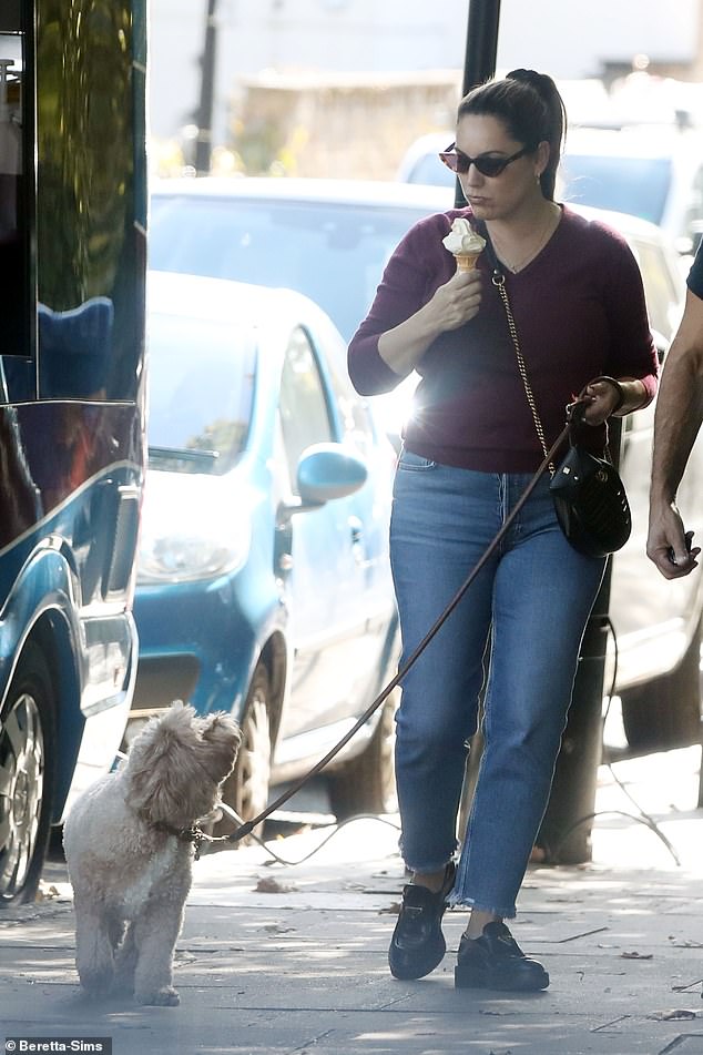 She enjoyed her ice cream in the sun, while her dog looked up hopefully