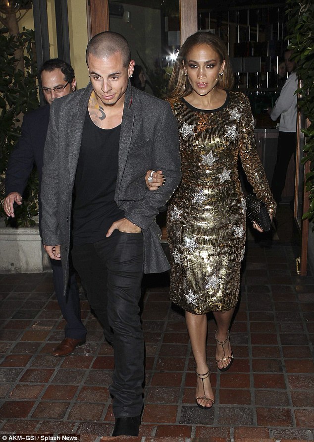 Jennifer Lopez steps out for dinner with boyfriend Casper Smart wearing a gold anti-paparazzo dress.