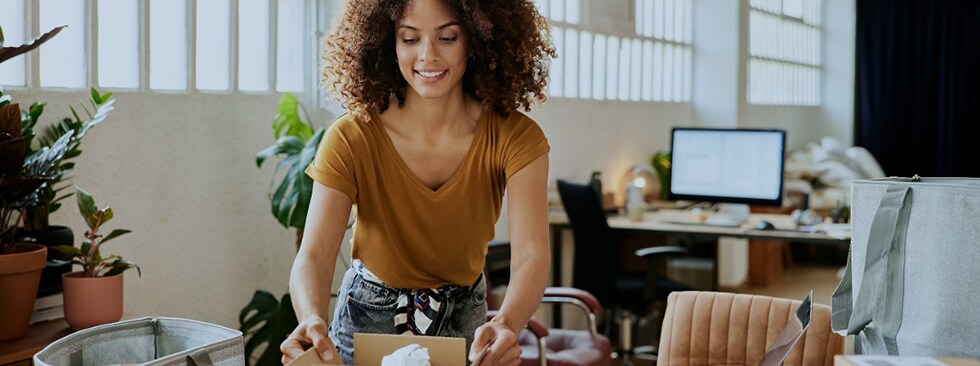 Businesswoman packing boxes at table