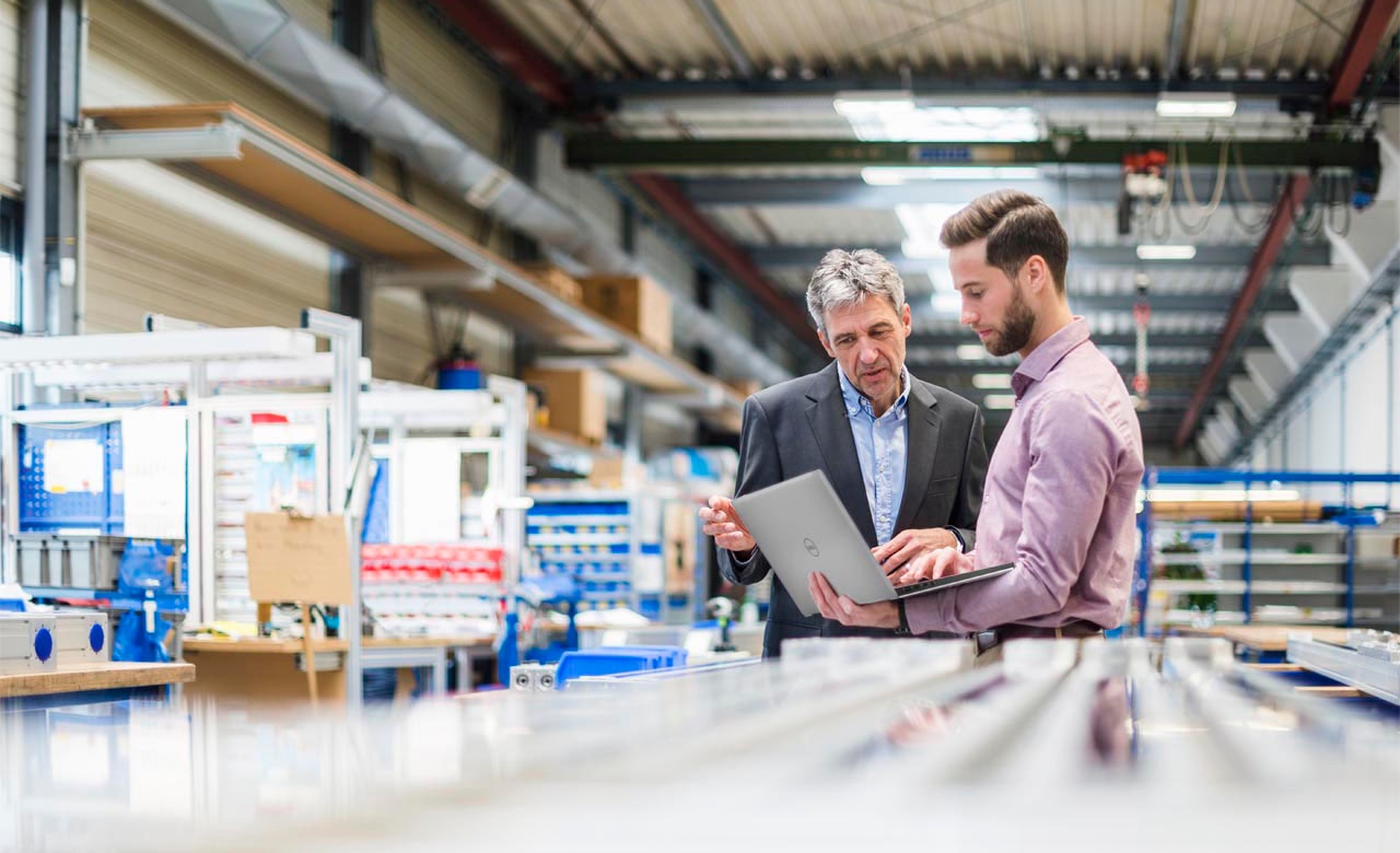 Businessmen using a Laptop in a Production Hall