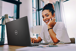 Young woman working at home, with her Dell laptop and a big smile.